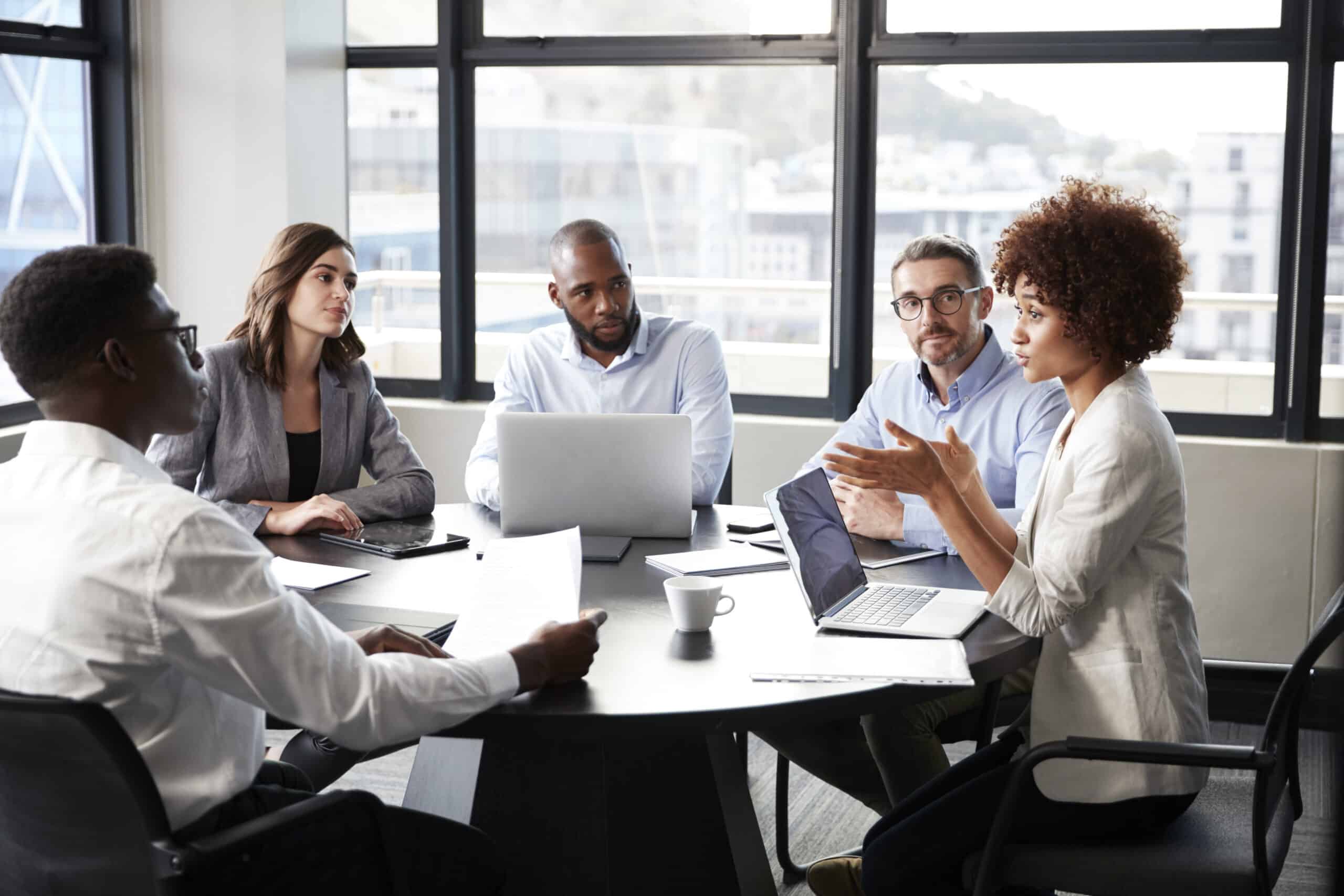 Millennial black businesswoman addressing colleagues at a corporate business meeting, close up Millennial black businesswoman addressing colleagues at a corporate business meeting, close up
